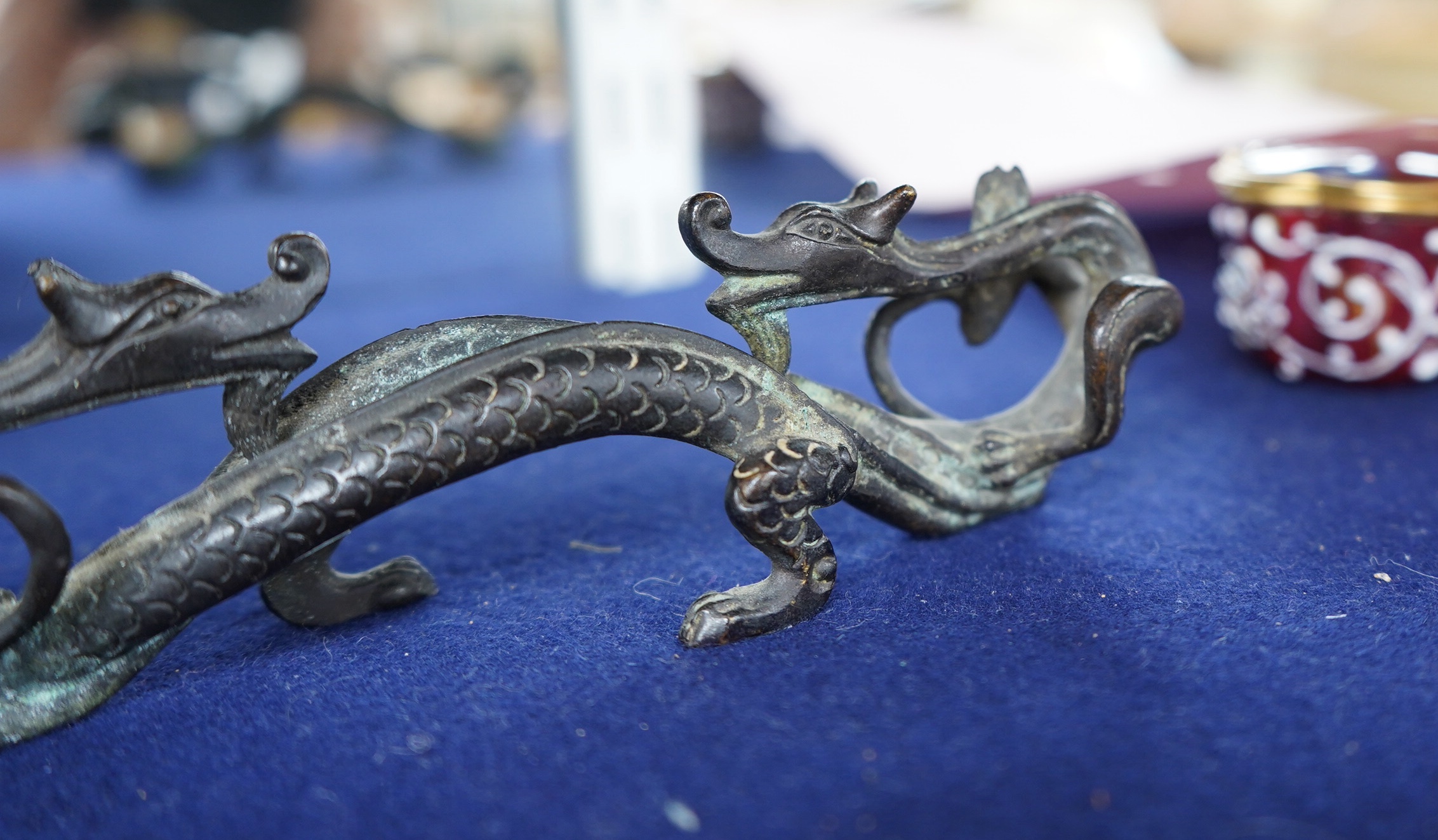 A Chinese bronze brush rest modelled as two dragons, 17cm wide. Condition - good